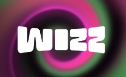 An image of the Wizz app logo. White lettering for the word 'Wizz' on a swirling background of pink, black and green colours.
